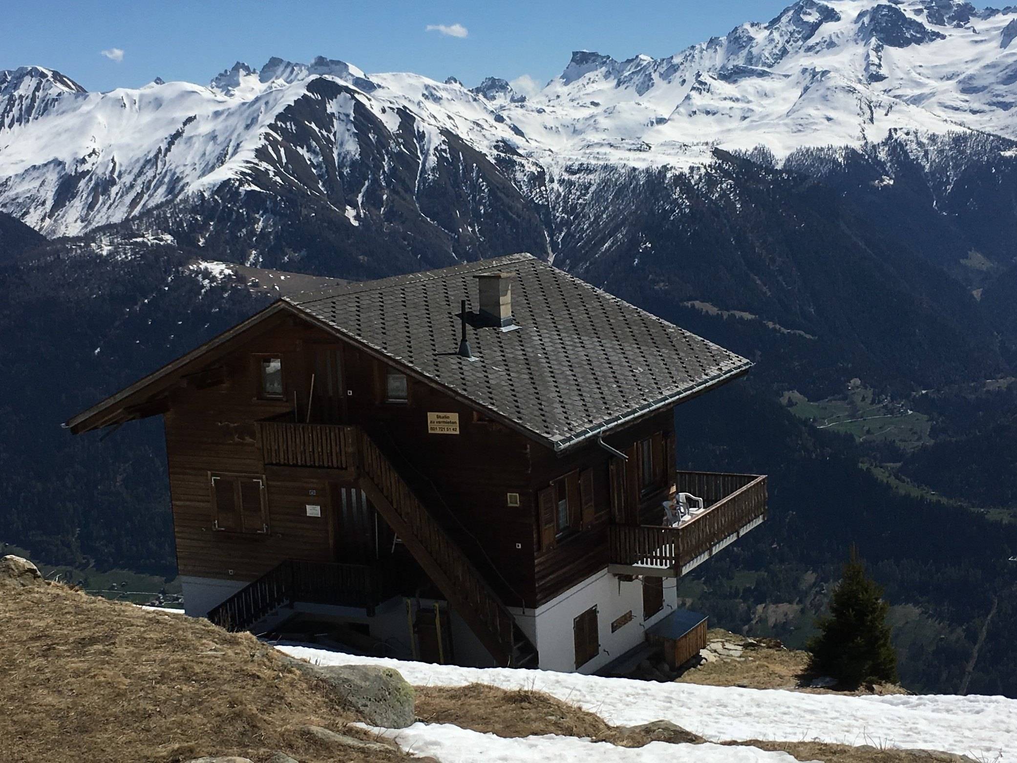 Chalet Bärgwind im Frühling vor verschneiten Gipfeln und dem Tal