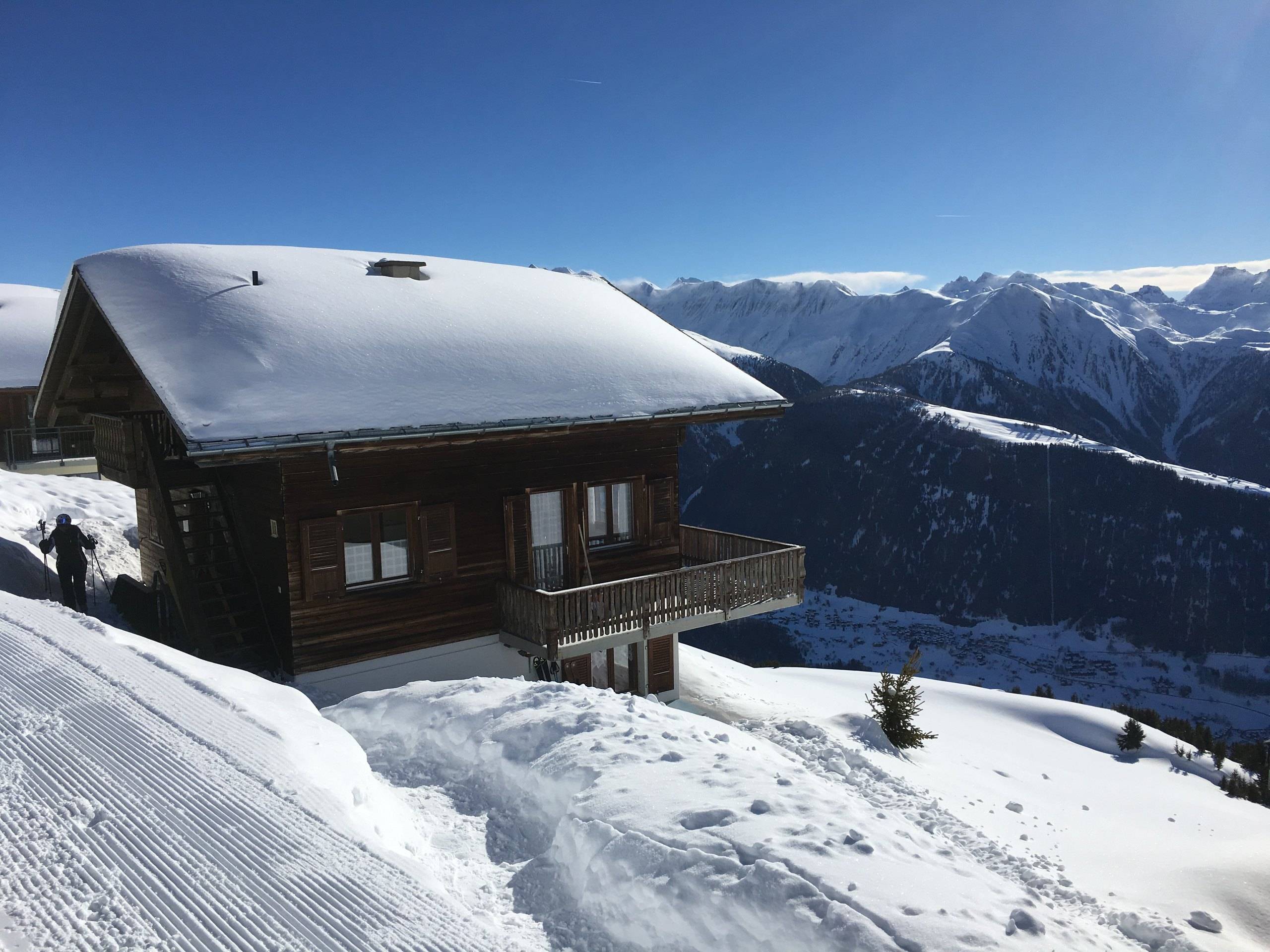 Chalet Bärgwind mit verschneitem Dach vor dem Bergpanorama im Winter