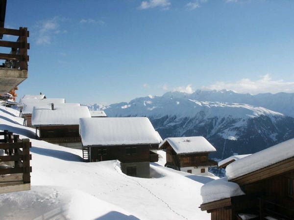 Verschneite Chalets auf dem Kühboden mit Bergpanorama im Winter